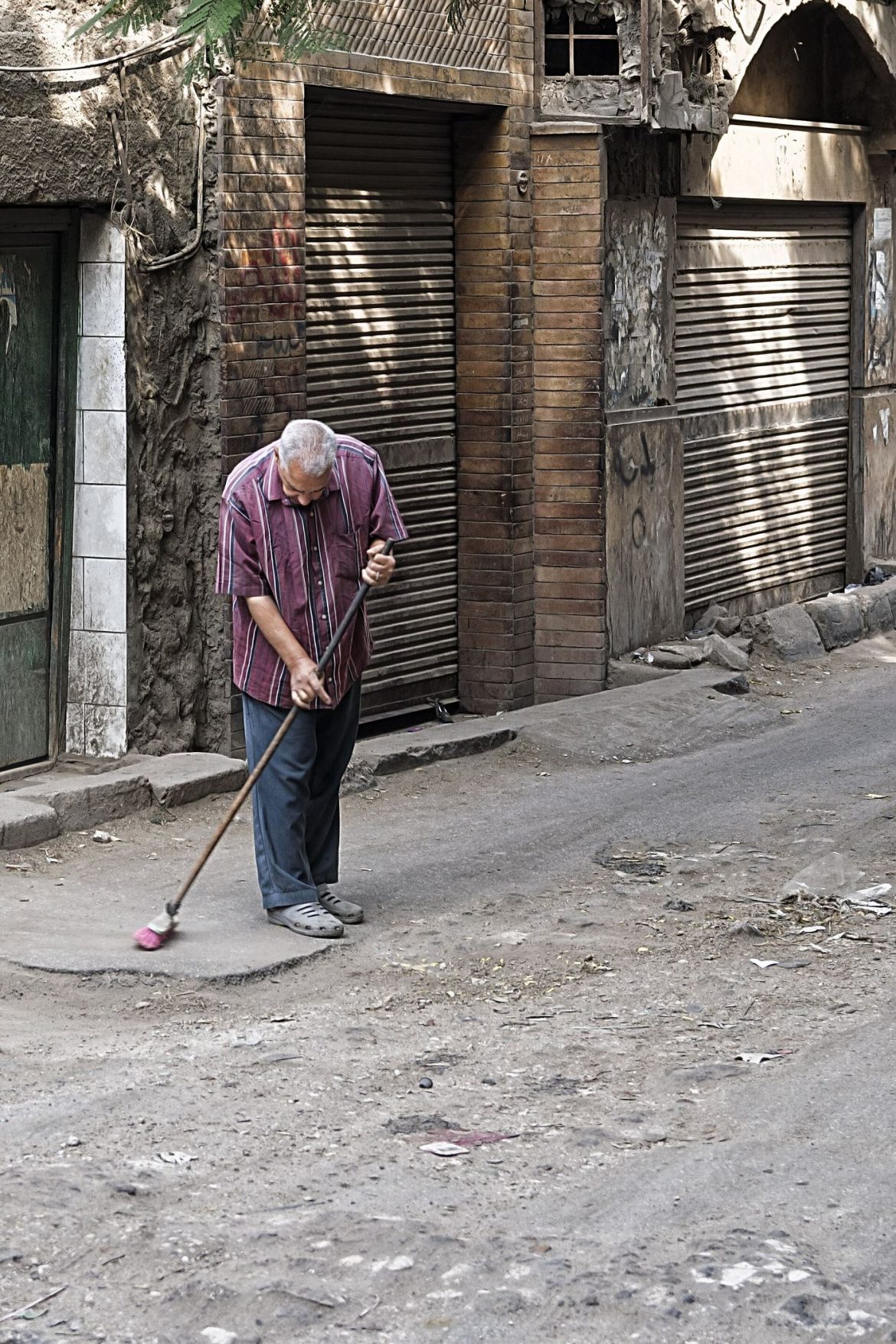 The owner of a small neighbourhood grocery shop at his storefront